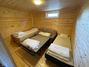 ein Zimmer mit zwei Betten und einer Couch in einer Kabine in der Unterkunft Room 1 in Hästveda