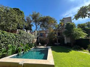 a swimming pool in the yard of a house at De la Mora Hostal in Fernando de la Mora
