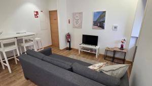 a living room with a couch and a table and a television at In Viana in Viana do Castelo