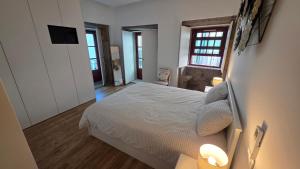 a bedroom with a white bed with two lights on it at In Viana in Viana do Castelo