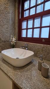 a white sink in a bathroom with a window at In Viana in Viana do Castelo +14 photos