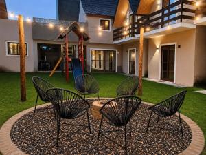 a patio with chairs and a playground in front of a house at Chalet Retreat of the Mountain in Bananeiras