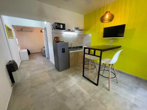 a small kitchen with a table and a refrigerator at Apart Hotel RioSol - Monoambientes in Concepción del Uruguay
