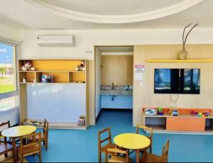 a classroom with two tables and a kitchen at Village Baixio Garden in Baixio