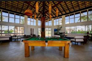a pool table in a large room with windows at Village Baixio Garden in Baixio