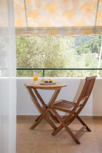 a wooden table and a chair in front of a window at Sofia and Soul Studios in Kalamitsi +23 photos