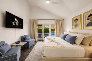 a bedroom with a large bed and a blue chair at NEW Royal Palms Retreat with Pool Spa & Pool Table in Tempe