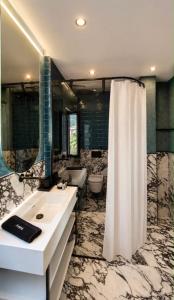 ein Badezimmer mit weißem Waschbecken und Dusche in der Unterkunft Luxury 1932 in Himarë