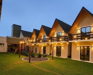 a house with a yard with chairs and lights at Chalet Retreat of the Mountain in Bananeiras