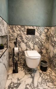ein Badezimmer mit weißer Toilette und Marmorwänden in der Unterkunft Luxury 1932 in Himarë