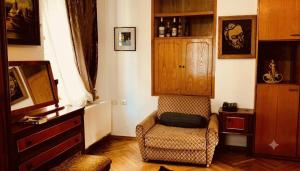 a living room with a chair and a cabinet at Vintageshvili hostel and guest house in Tbilisi City +12 photos