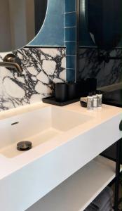 eine Badezimmerablage mit Waschbecken und Spiegel in der Unterkunft Luxury 1932 in Himarë