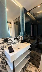 ein Badezimmer mit Waschbecken und großem Spiegel in der Unterkunft Luxury 1932 in Himarë