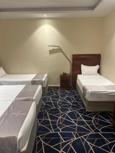 a hotel room with two beds and a carpet at فندق كرمك اجياد السد in Ajyad +3 photos