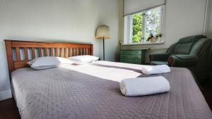 a bedroom with a bed with a chair and a window at Hostel Lõuna in Pärnu +30 photos