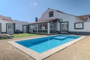 a swimming pool in front of a house at Canto Celeste in Alcobaça