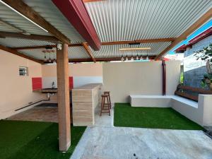 an outdoor room with a table and a bench at Villa R-A in Kourou