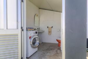 a small bathroom with a washing machine and a sink at Canto Celeste in Alcobaça