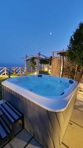 a hot tub with a chair and a bench at Otium Relais in Furore
