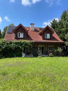 a house with a roof with solar panels on it at Artystycznie nad Bugiem 1 in Gnojno