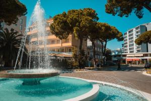 a fountain in the middle of a street at Appartamento Antares Piazza Fontana in Lignano Sabbiadoro