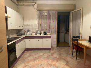 a kitchen with white cabinets and a table and a dining room at Big Brother Bed & Rooms in Treviso
