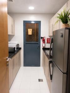 a kitchen with a blue door and a refrigerator at Travellers Deluxe Apartment in Muscat +7 photos