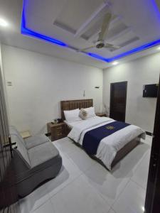 a bedroom with a bed and a chair and blue lights at Abu Khalid By MZ Hotels & Restaurant in Mingāora