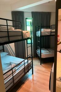 a room with three bunk beds and a window at GoStay Pods at Perak Road in Singapore