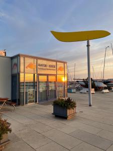 a building with a large yellow umbrella next to a marina at Gönn Dir eine Auszeit! An der Ostsee in Kiel