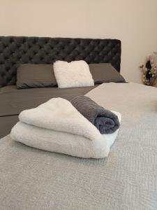 a pile of towels sitting on top of a bed at Green view apartman Pančevo in Pančevo