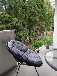 a chair sitting on a balcony with a glass table at Green view apartman Pančevo in Pančevo