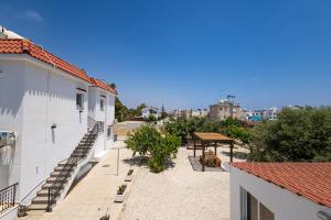 a view of a patio with a picnic table and buildings at Olive Grove Apartments in Larnaca
