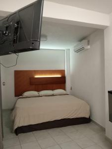 a bedroom with a bed with a flat screen tv above it at Hotel Bora Bora Acapulco in Acapulco +3 photos