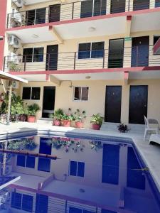 a house with a swimming pool in front of a building at Hotel Bora Bora Acapulco in Acapulco