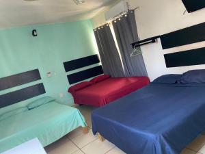 a room with two beds and a chair in it at Hotel Bora Bora Acapulco in Acapulco