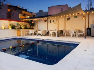 a swimming pool with a table and chairs next to a building at Hotel Bora Bora Acapulco in Acapulco