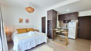 a bedroom with a bed and a small kitchen at Sunny Stay Ezeiza in Ezeiza