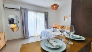 a room with a bed and a table with wine glasses at Sunny Stay Ezeiza in Ezeiza
