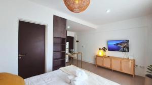 a bedroom with a bed and a tv on the wall at Sunny Stay Ezeiza in Ezeiza +34 photos