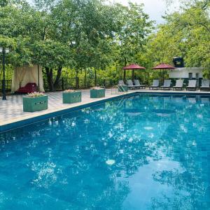 a large swimming pool with chairs and a gazebo at Mounts Edge Regency in Mahiyangana