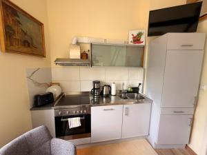 a small kitchen with a sink and a refrigerator at Gemütliches Apartment in zentral mit Balkon in Bremen