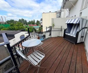 a deck with a table and chairs on a balcony at Gemütliches Apartment in zentral mit Balkon in Bremen