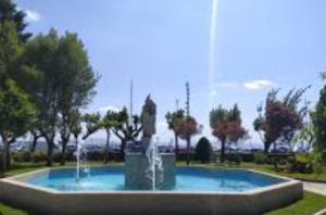 a fountain with a statue in the middle of a park at Villa HEGODEI in A Pobra do Caramiñal