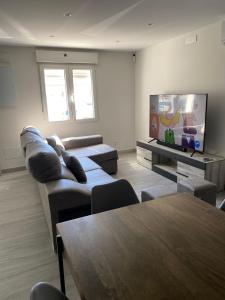 a living room with couches and a flat screen tv at Villa HEGODEI in A Pobra do Caramiñal