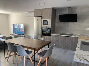 a kitchen with a table and chairs and a television at Villa HEGODEI in A Pobra do Caramiñal