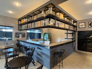 a restaurant with a bar with black chairs and tables at Hotel Paddock in São Paulo +15 photos