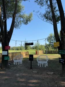 two benches in a park with a playground at Taverna e liqenit in Shtoji i Vjetër