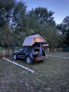a car with a tent on the top of it at Taverna e liqenit in Shtoji i Vjetër
