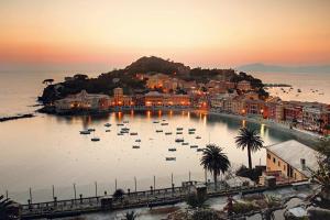 a town with boats in the water at sunset at Villa Domus 1938 in Sestri Levante
